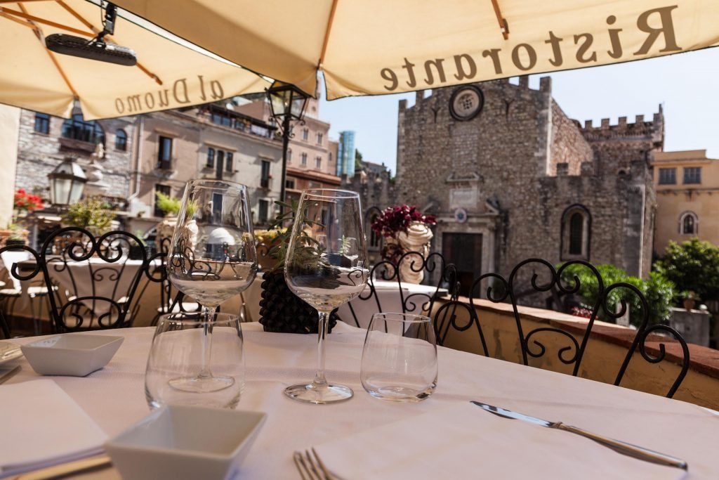 Un tavolo con ombrelloni e un castello sullo sfondo