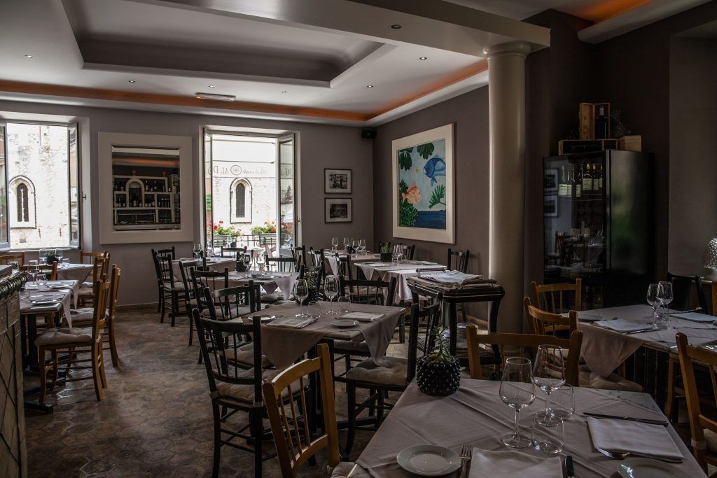 Una grande sala da pranzo piena di tavoli e sedie.