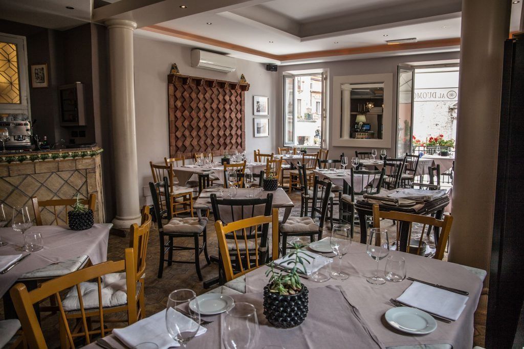 Una grande sala da pranzo piena di tavoli e sedie.