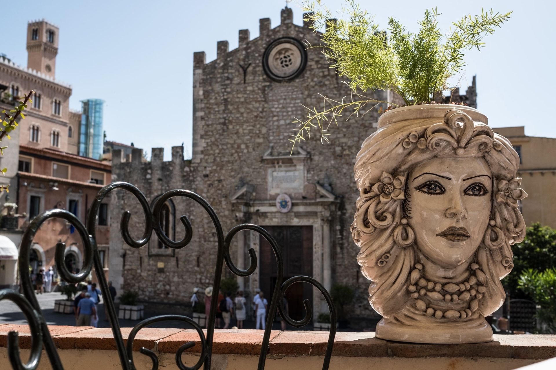 Una statua raffigurante una testa di donna è posta di fronte a un edificio.