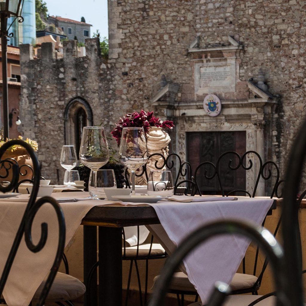 Un tavolo con una tovaglia bianca e un vaso di fiori sopra