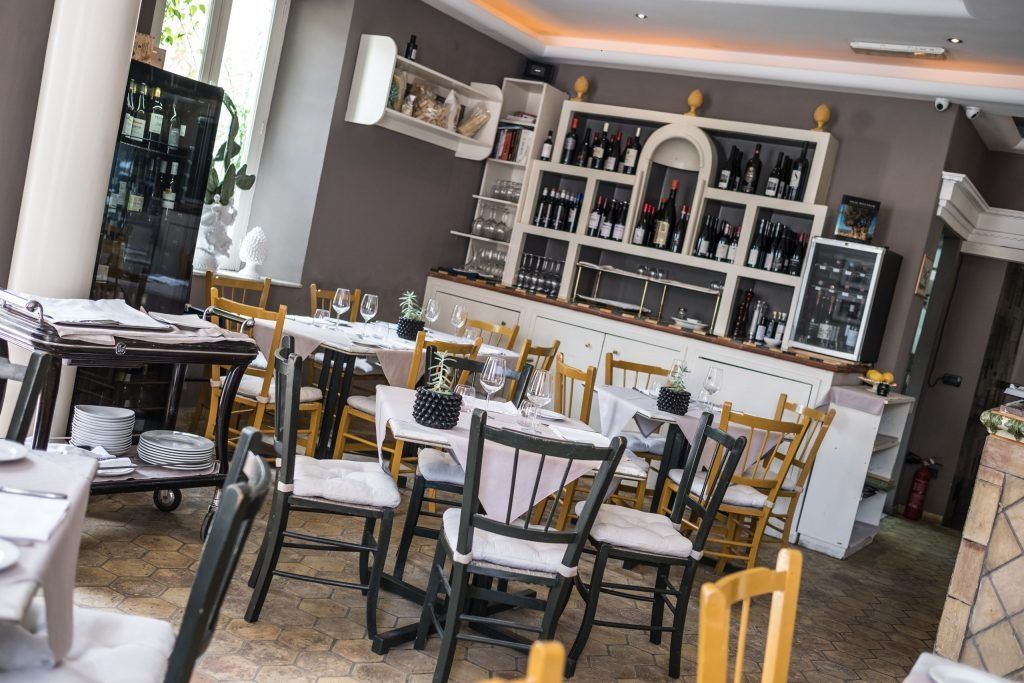 Un ristorante pieno di tavoli, sedie e un bar.