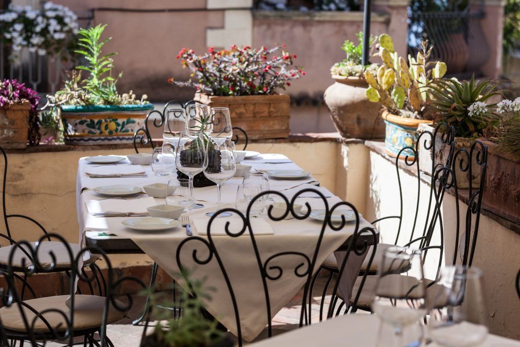Un ristorante con tavolo e sedie apparecchiati per un pasto.