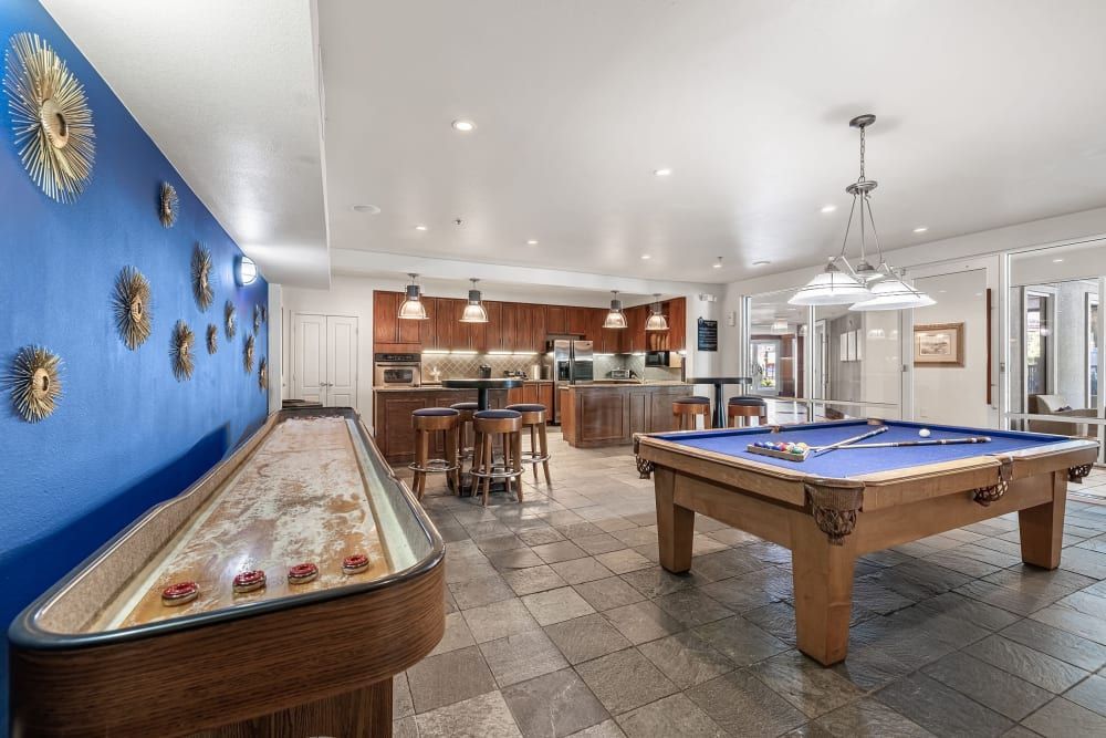 Apartment entertainment lounge with pool table and a shuffleboard table at Marquis at Texas Street in Dallas, TX.