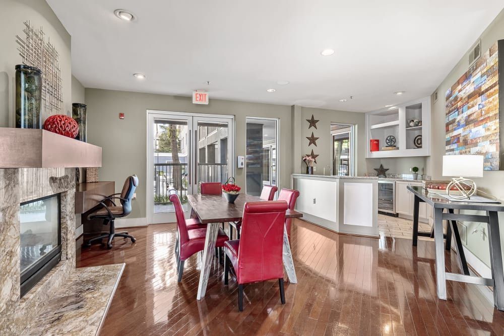 Spacious living room with a table and chairs and a fireplace at Marquis at Texas Street in Dallas, TX.