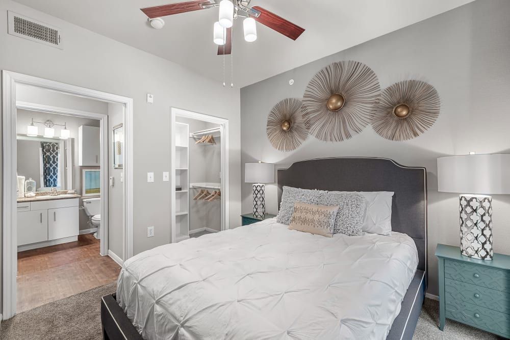 Modern bedroom with a large bed and a ceiling fan at Marquis at Texas Street in Dallas, TX.