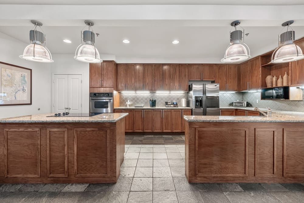 Apartment community kitchen with wooden cabinets and granite counter tops at Marquis at Texas Street in Dallas, TX.