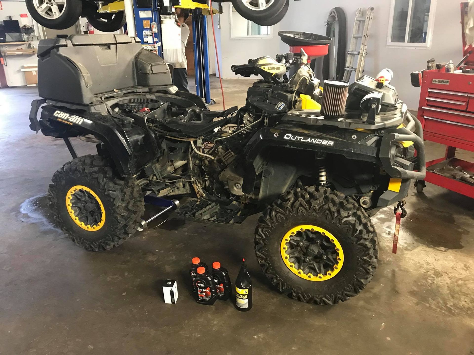A black and yellow atv is parked in a garage.