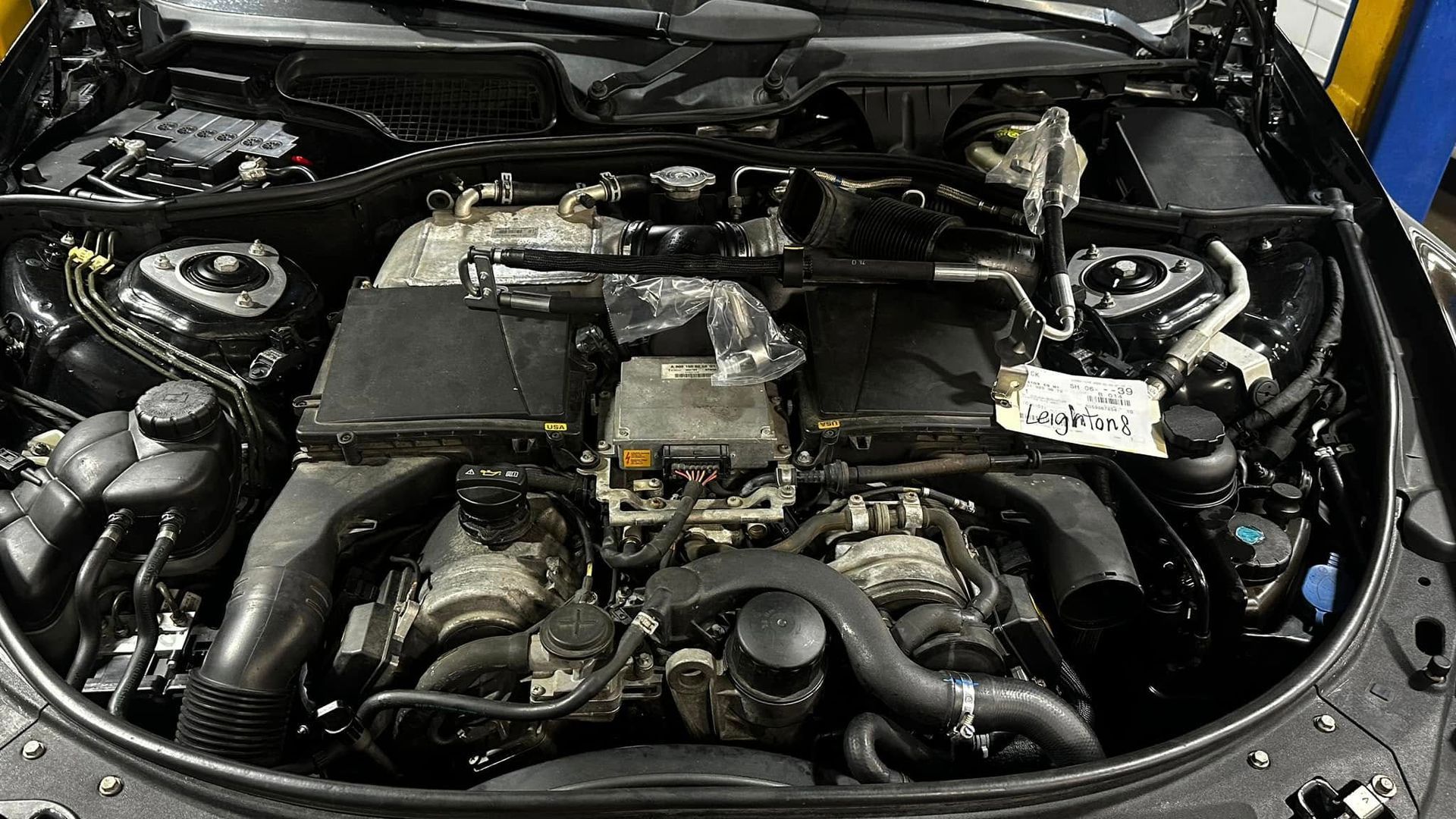 A close up of the engine of a car with the hood open.