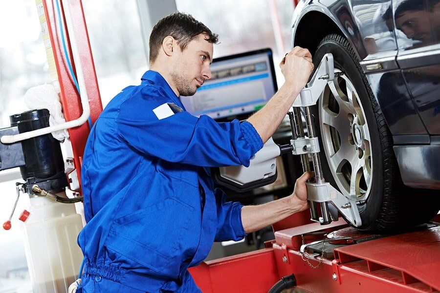 Man Aligning The Car Tire — Richmond Valley Tyres in Casino
