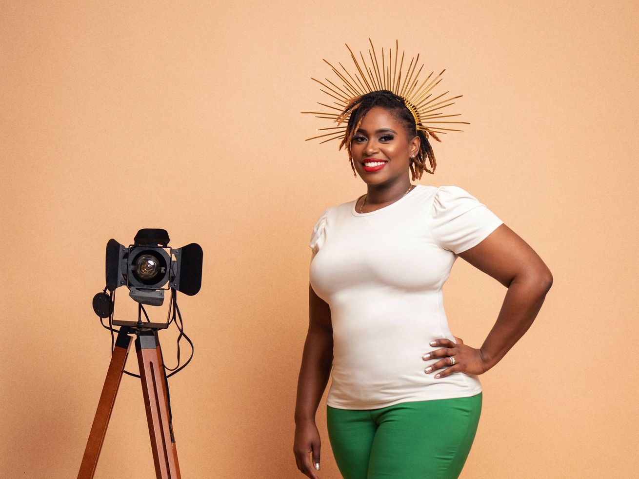 A woman is standing in front of a camera on a tripod.