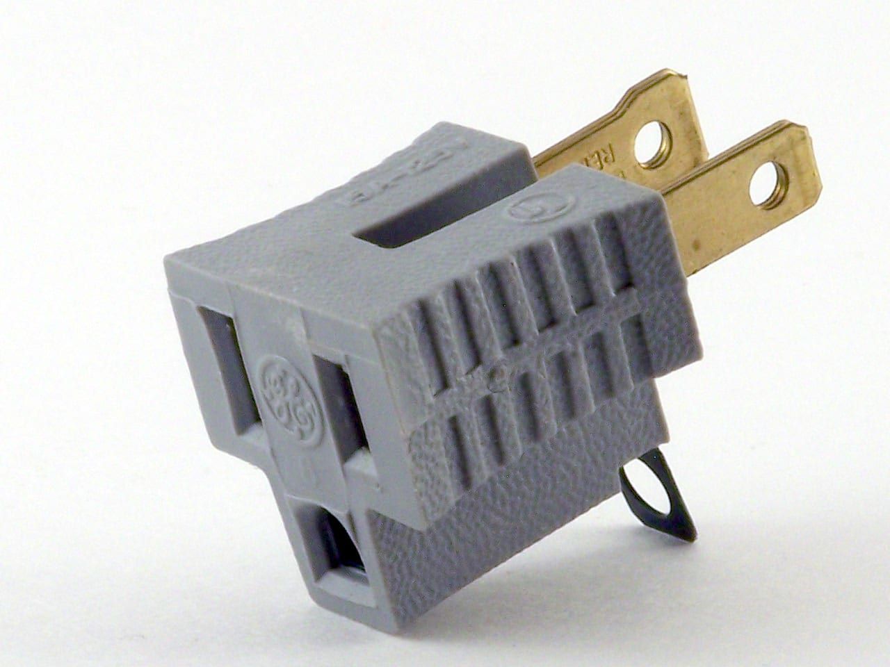 A close up of a gray electrical adaptor plug on a white surface