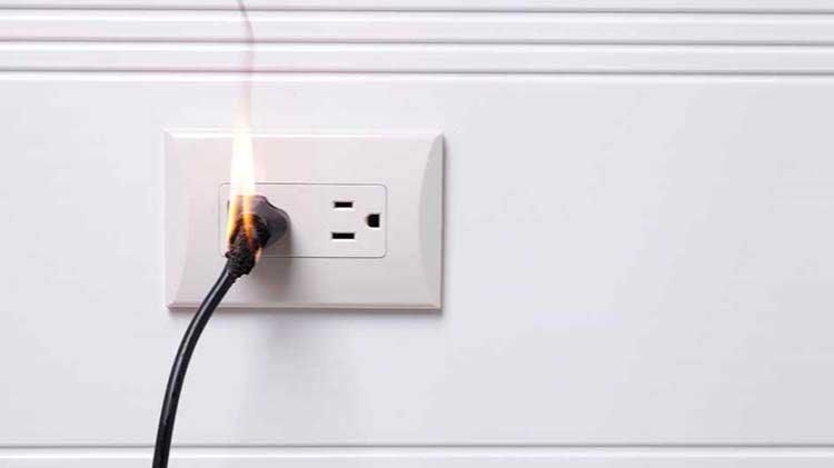 A plug in a wall outlet is catching fire