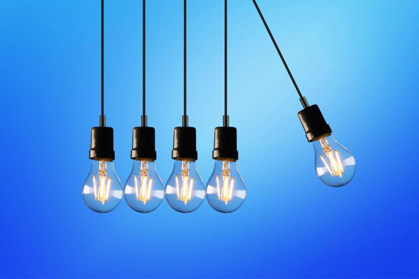 A row of light bulbs hanging from a string on a blue background.