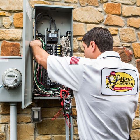 Mister Sparky Electrician in a white shirt fixes an overloaded circuit