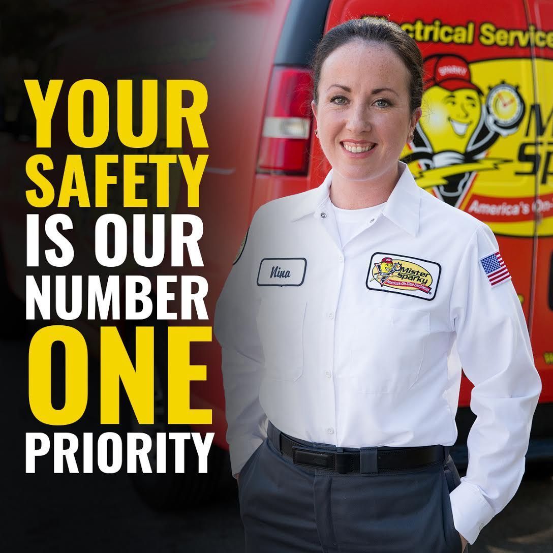 A woman standing in front of an electrical service truck that says your safety is our number one priority