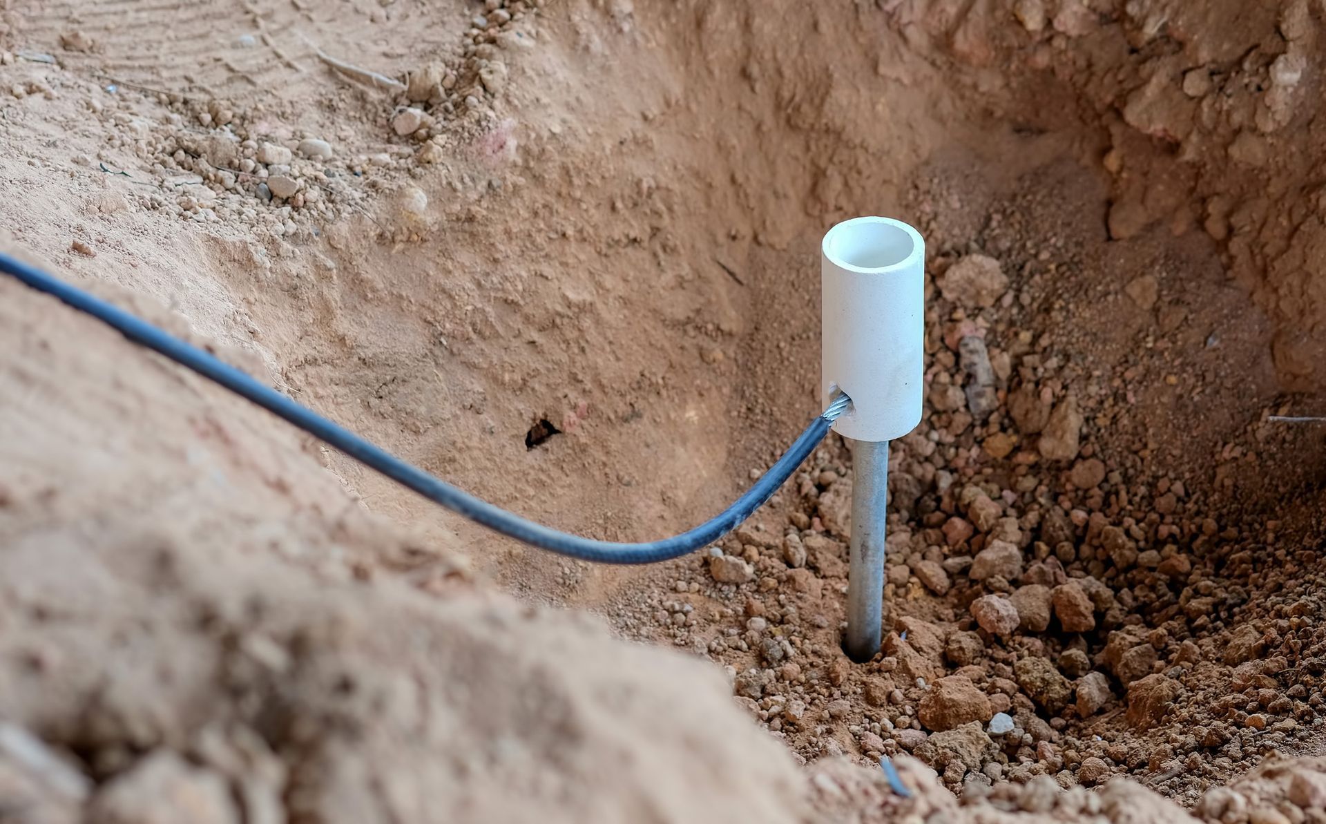 A ground rod in the dirt connected to a ground wire.