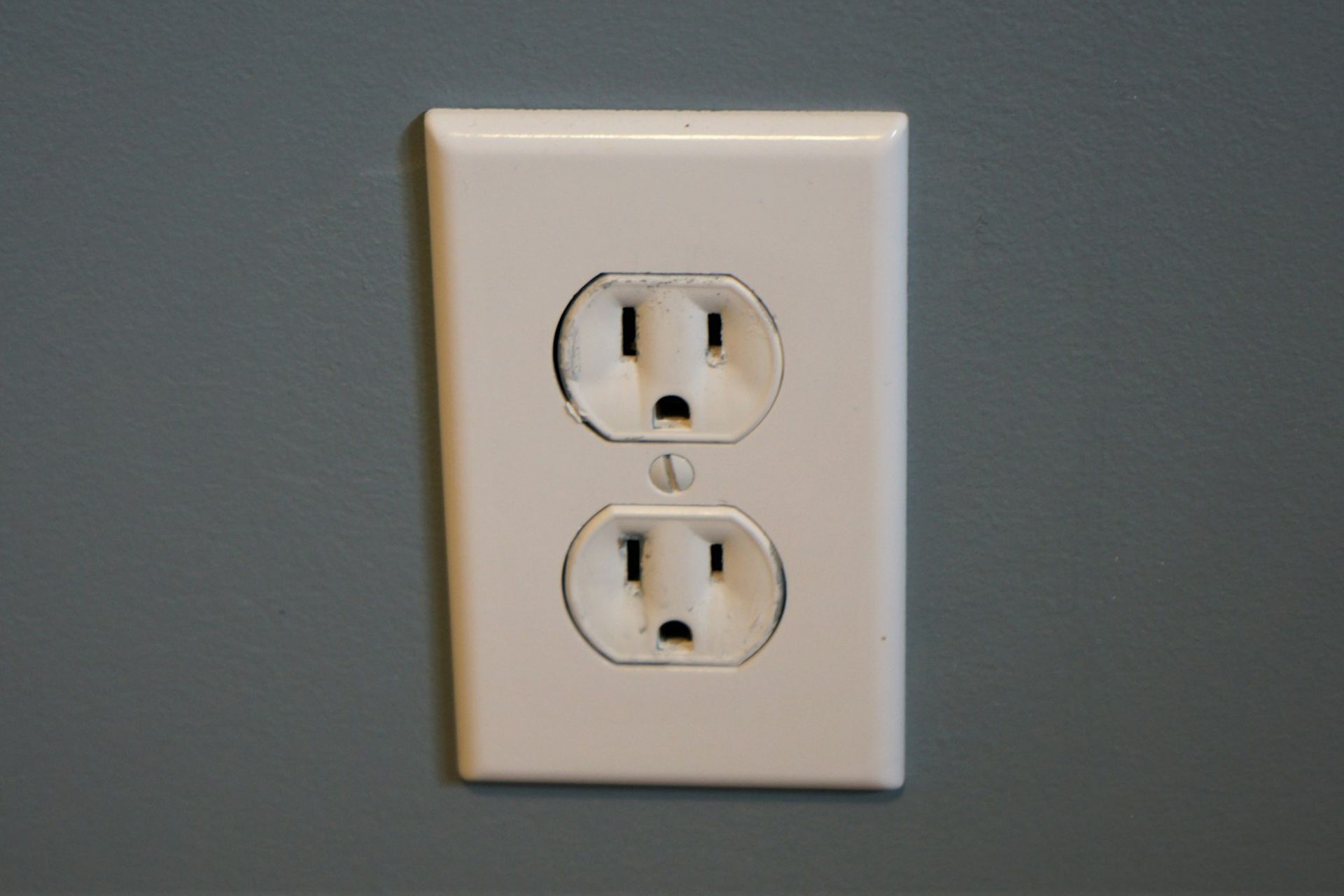 A white electrical outlet on a gray wall