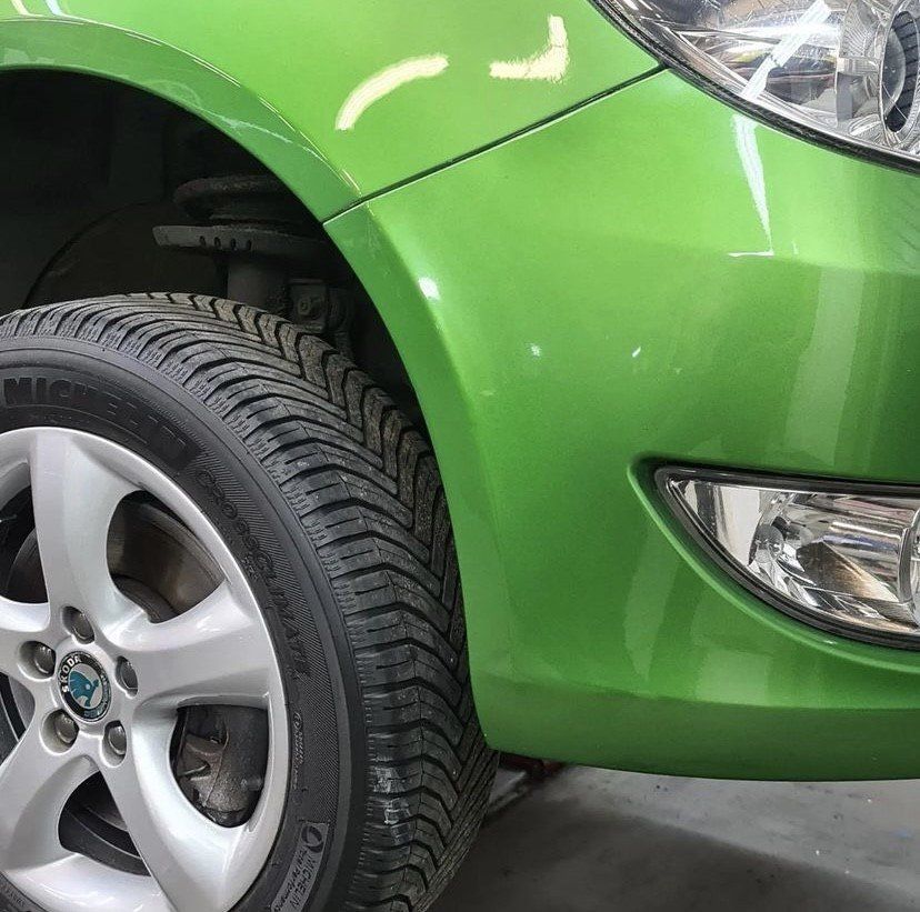 Een groene auto met een nieuwe gespoten kleur. spotrepair hersteld. 