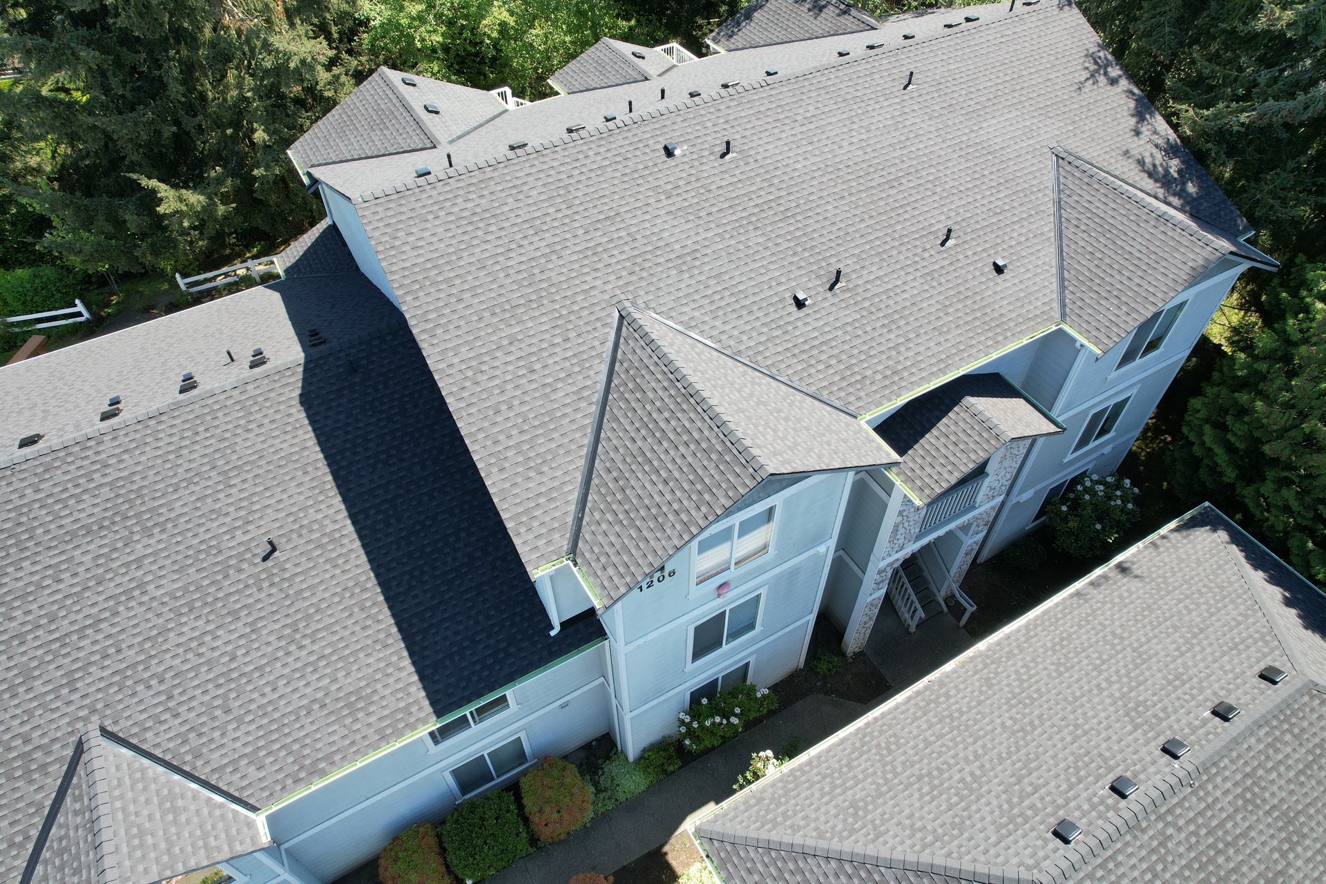 An aerial view of a house with a gray roof taken by Riverside Roofing
