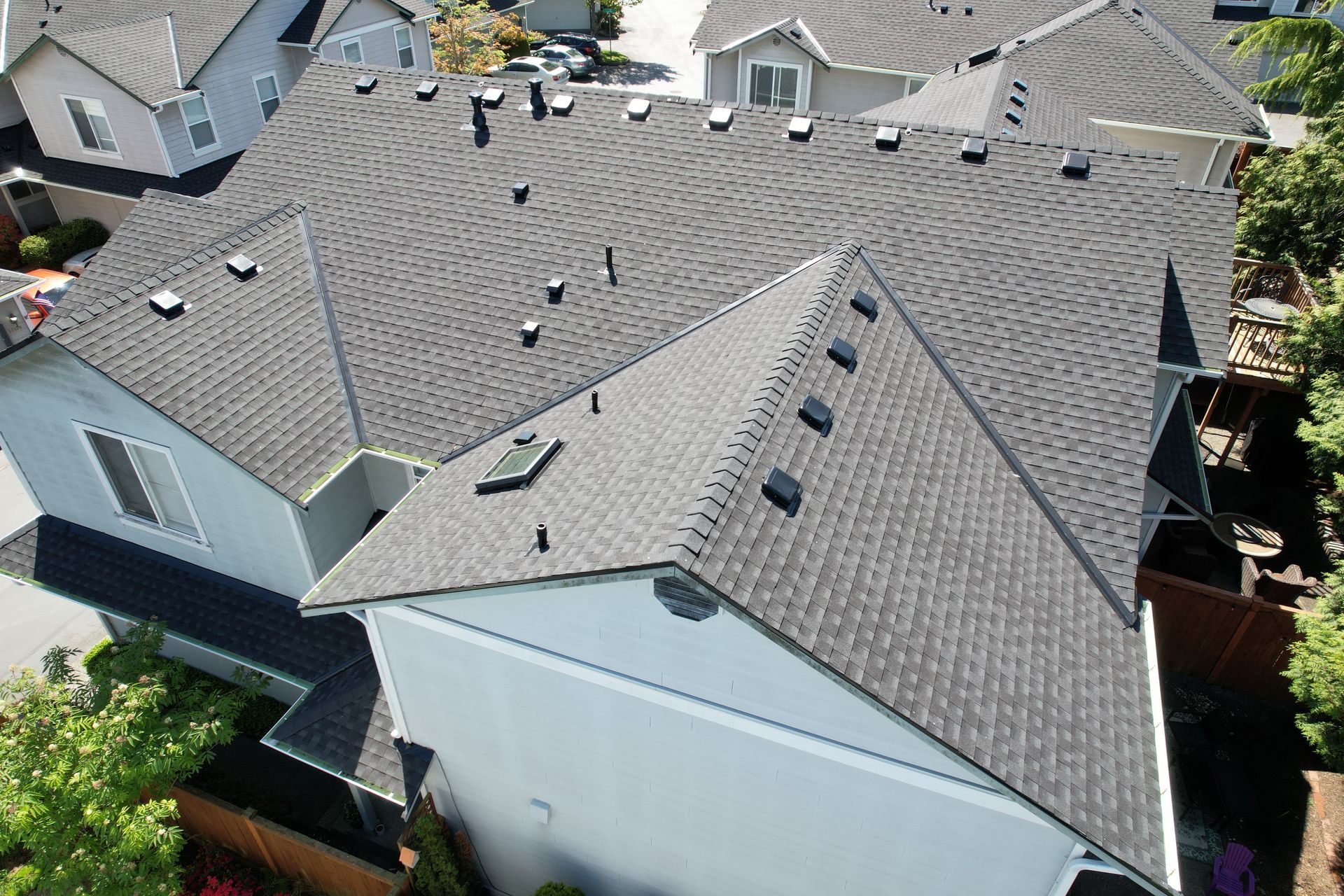 An aerial view of a roof of a house in a residential area taken by Riverside Roofing