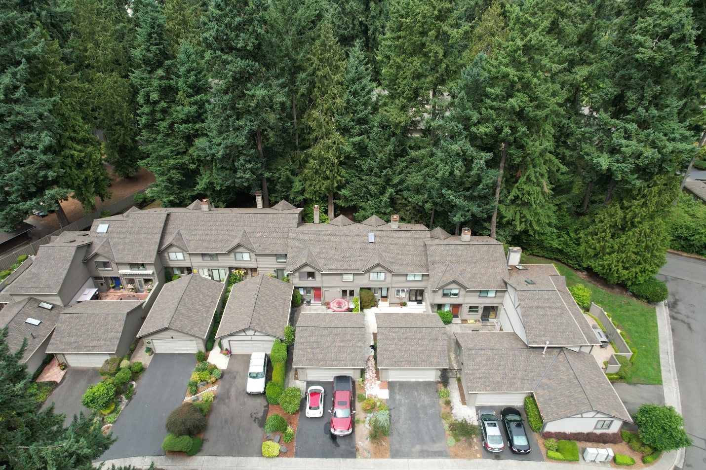 An aerial view of a row of houses surrounded by trees.