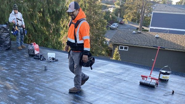 A man is walking on the flat roof of a commercial building.