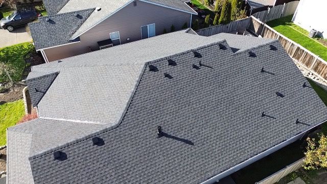 An aerial view of a house with a new roof taken by Riverside Roofing