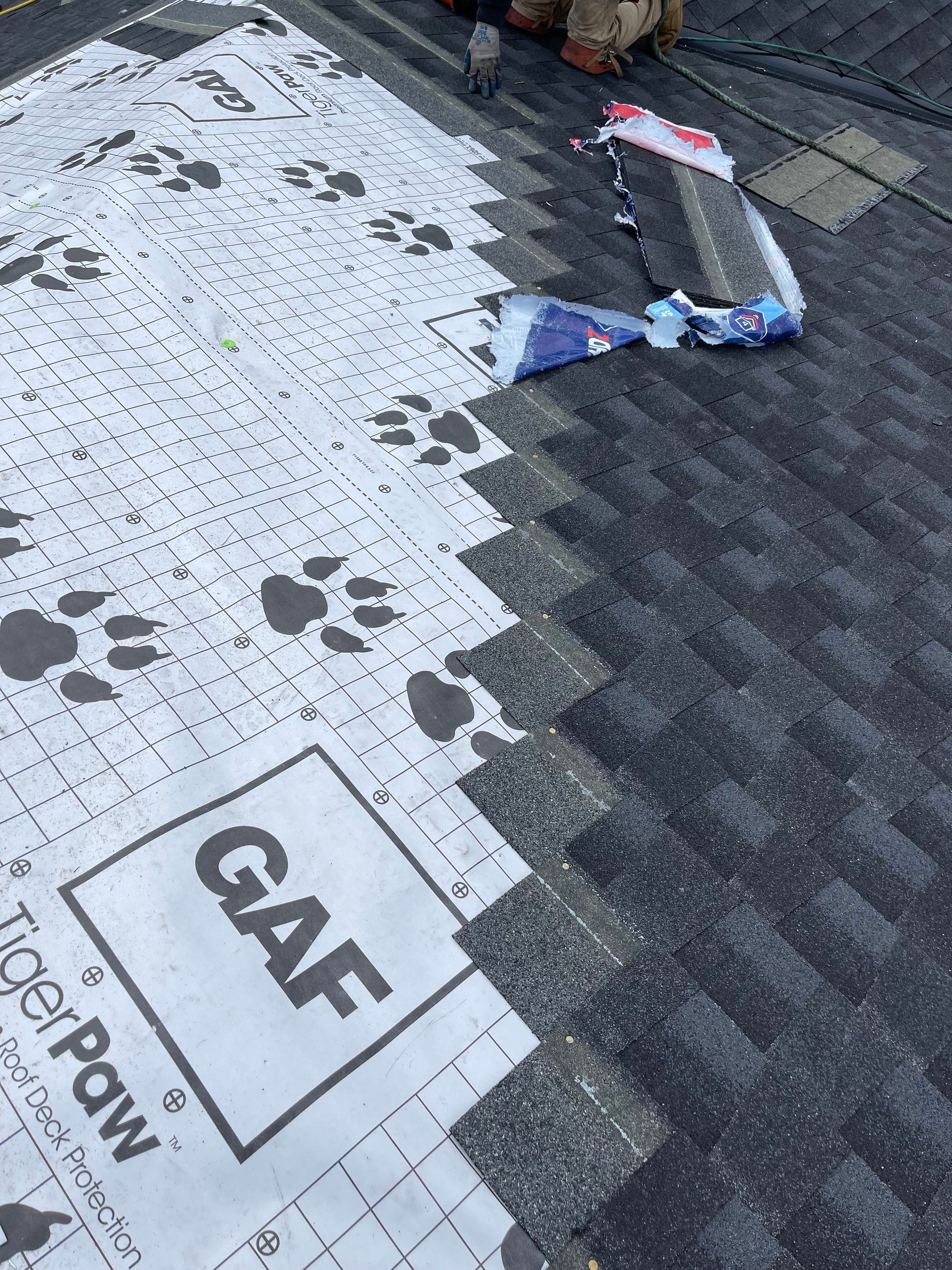 A person is working on a roof with a piece of paper on it taken by Riverside Roofing