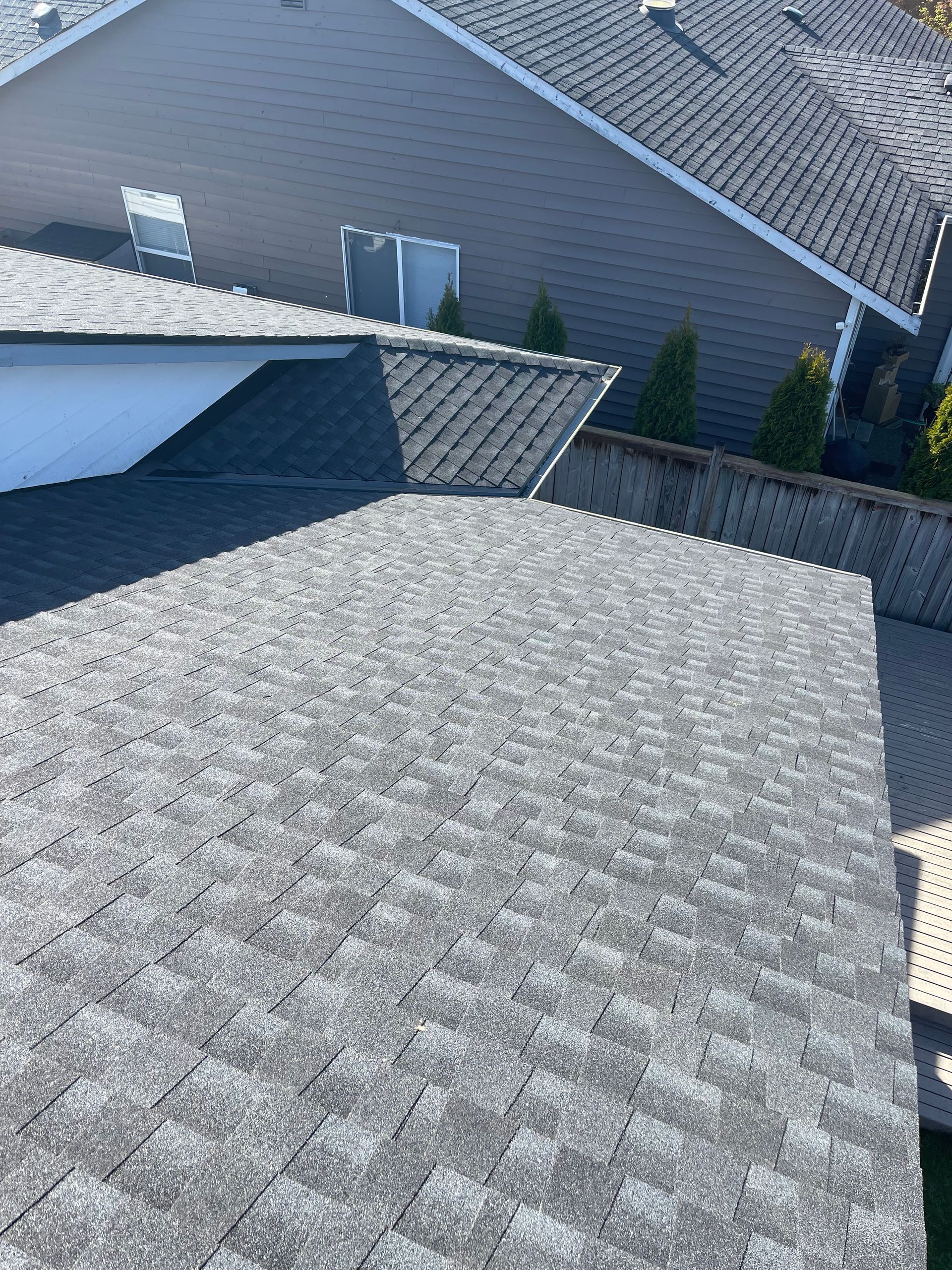 The roof of a house with a gray shingle roof taken by Riverside Roofing