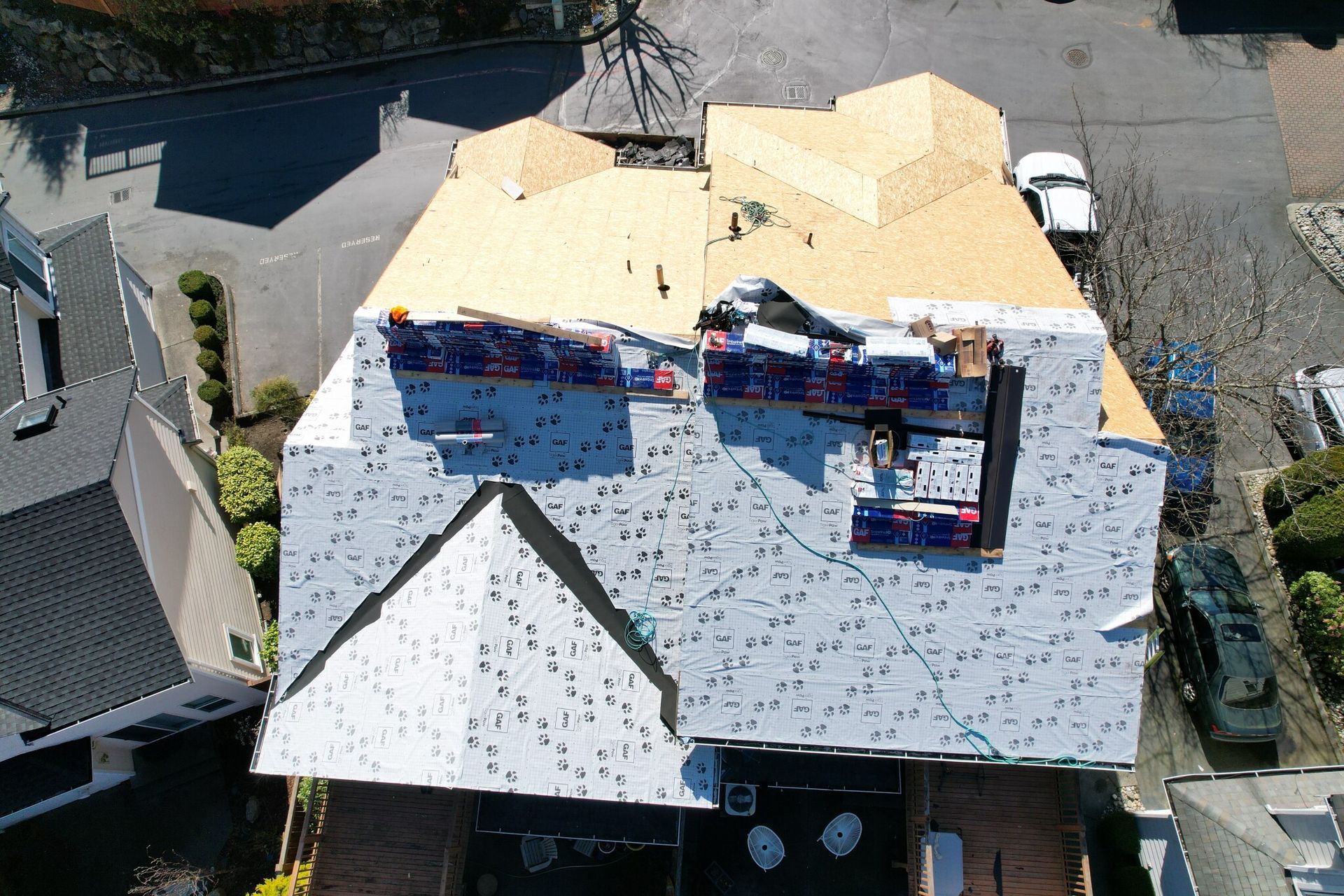 An aerial view of a house with a roof under construction taken by Riverside Roofing