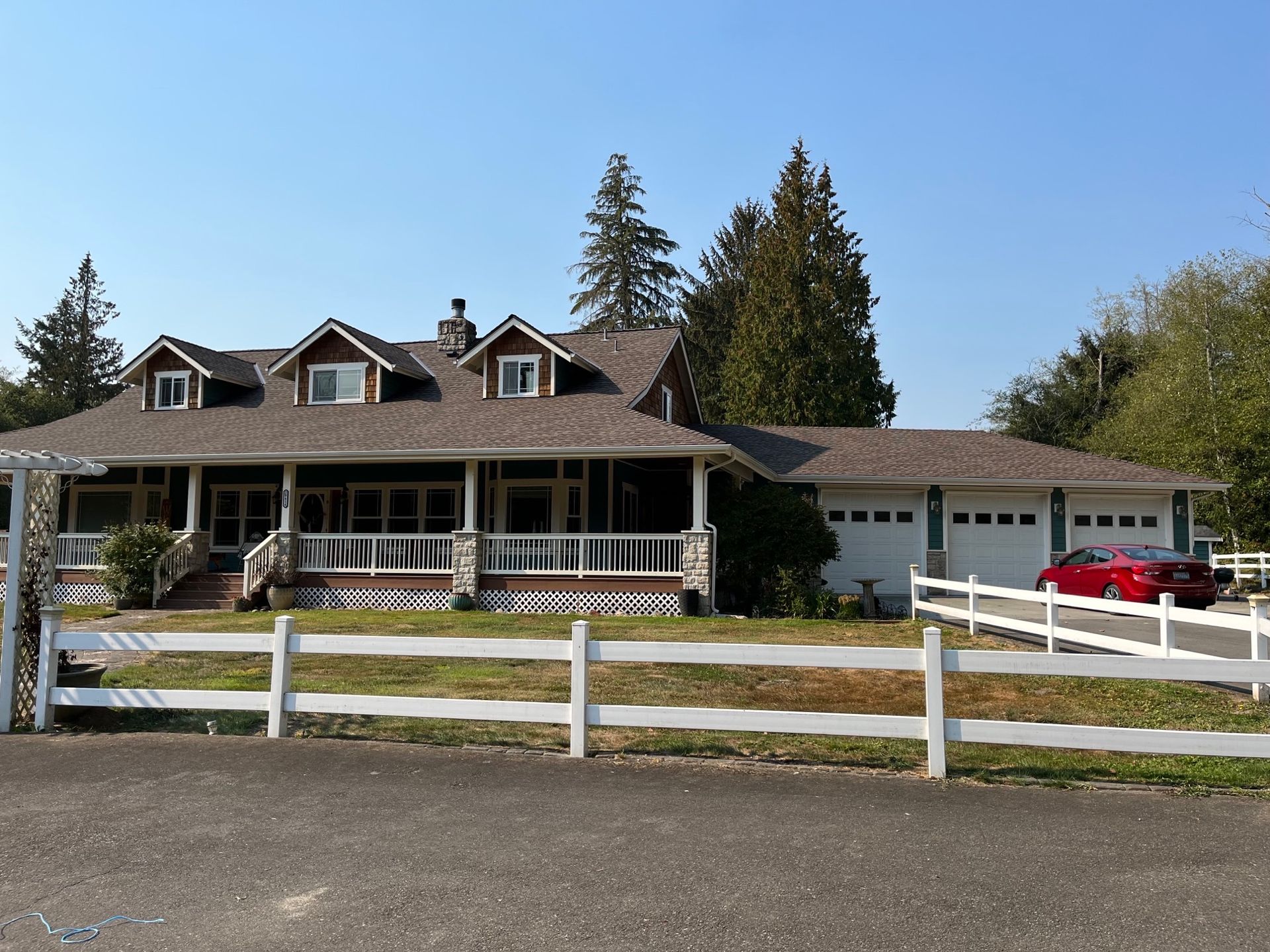 A large house with a white fence in front of it taken by Riverside Roofing