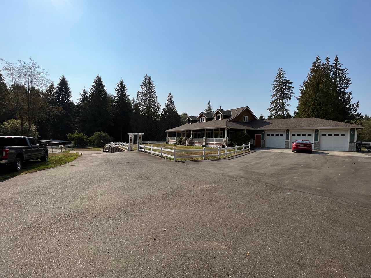 A large house with a lot of cars parked in front of it taken by Riverside Roofing