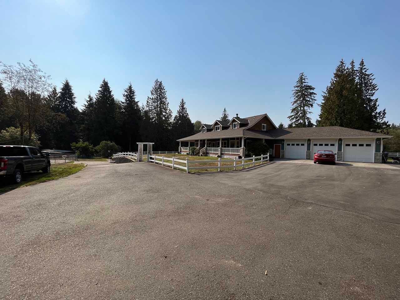 A house with two garages and a fence in front of it taken by Riverside Roofing