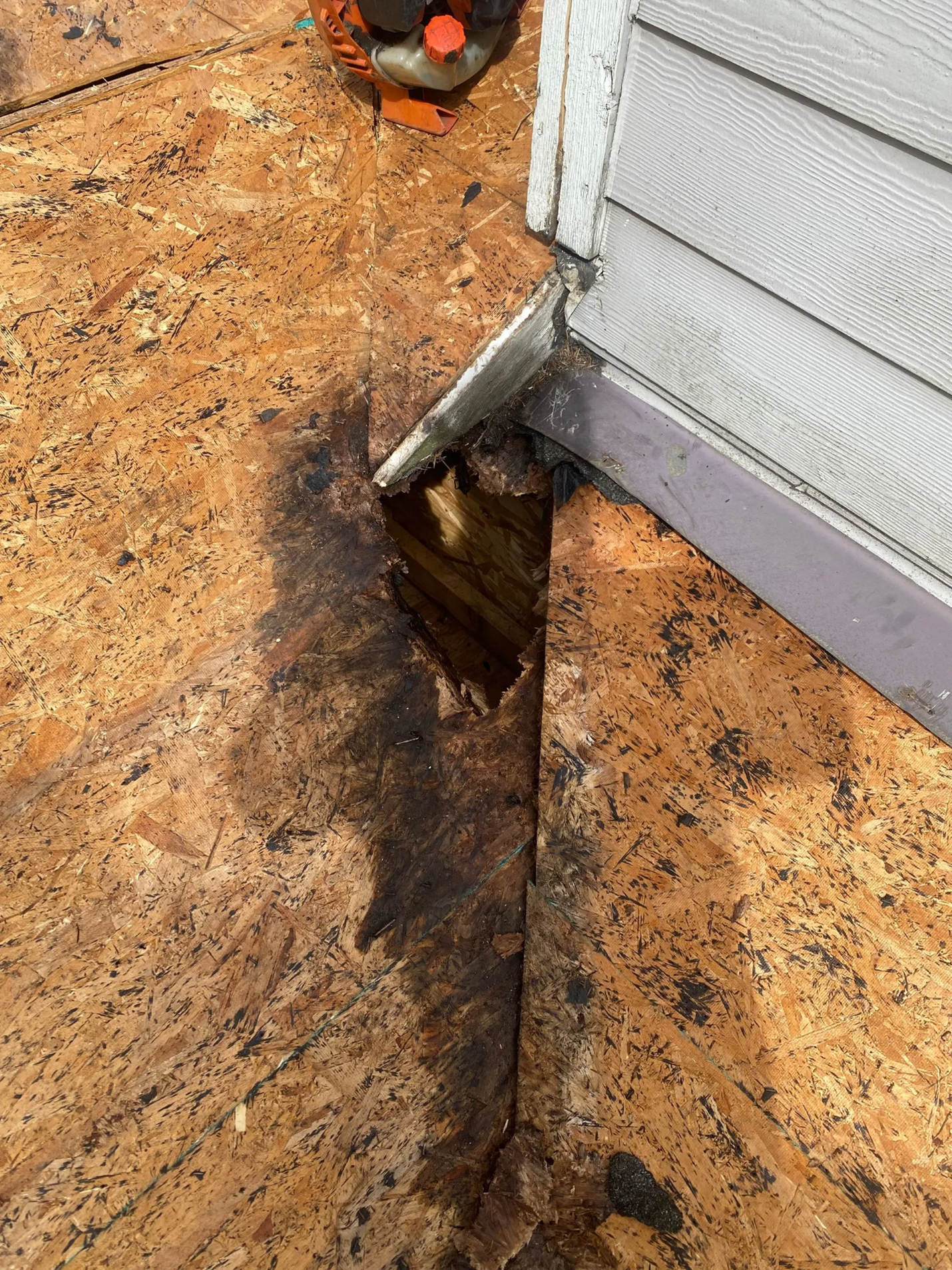 A close up of a piece of wood next to a house.