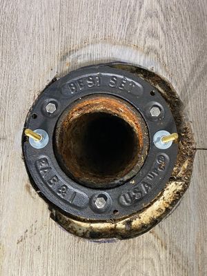 A close up of a metal flange on a wooden surface.