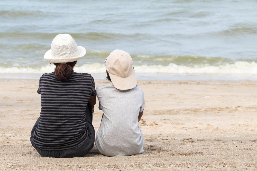 divorced mother and son on beach talking about stages of grief