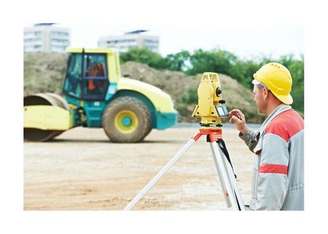 Construction worker setting up instruments for construction measurements
