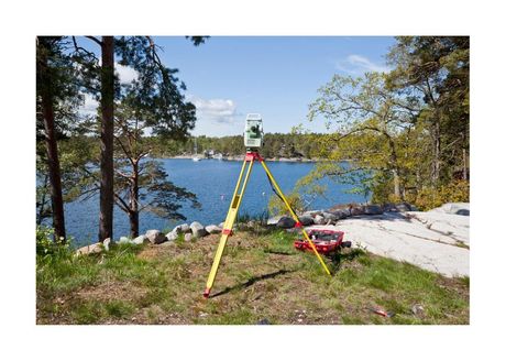 surveyor tripod setup on landing in front of a lake