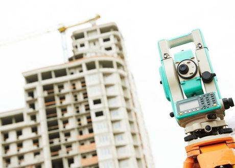 tripod in front of high-rise under construction