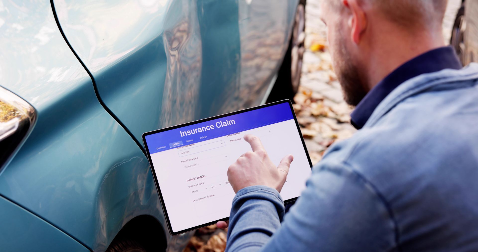 Vehicle insurance agent assesses car crash damage.