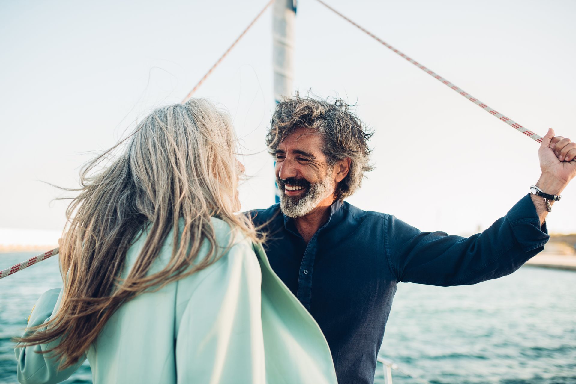 A mature man and his wife enjoy sailing on their boat, showcasing reliable boat insurance.
