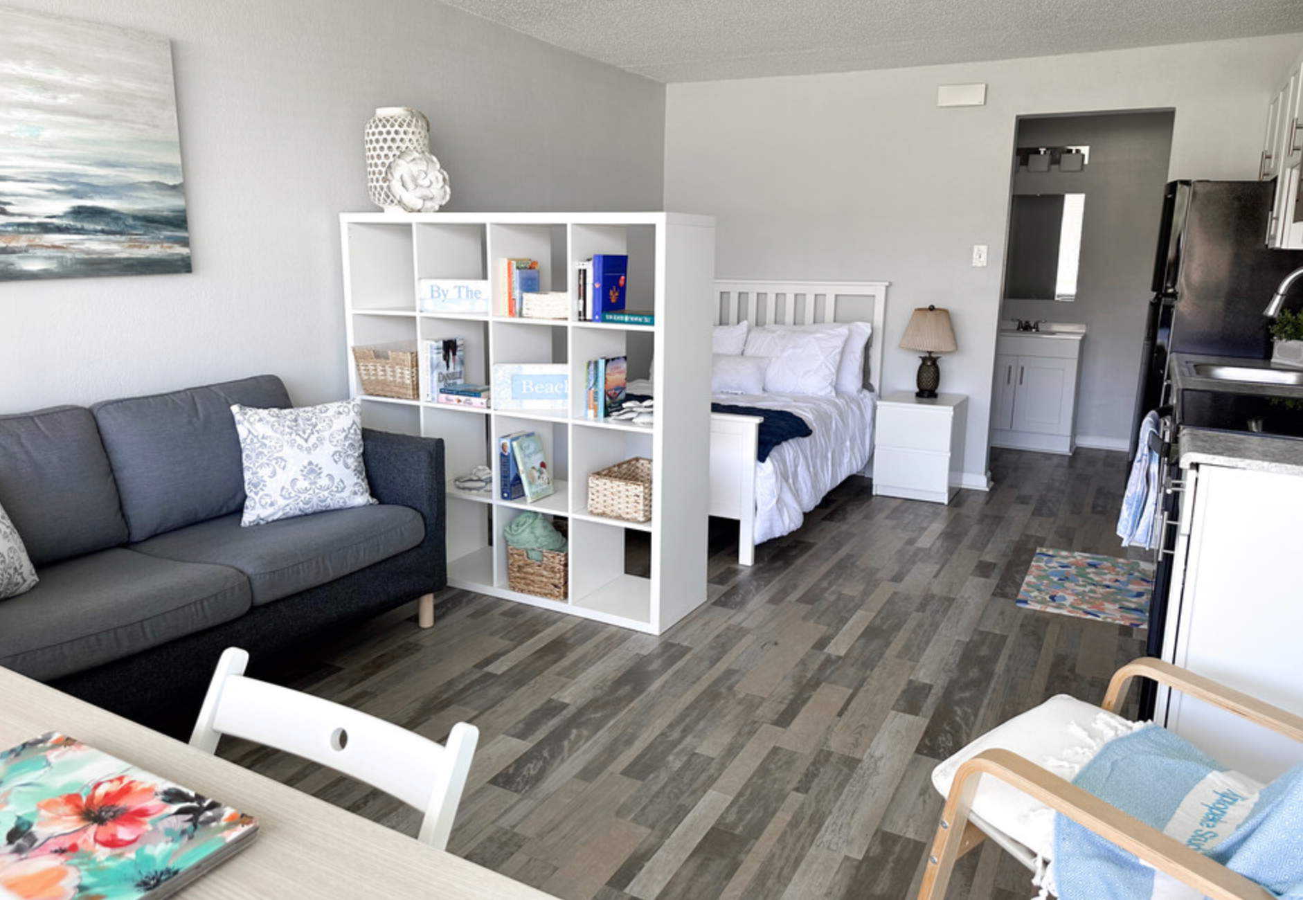 A living room with a couch , table , chairs and a bed.