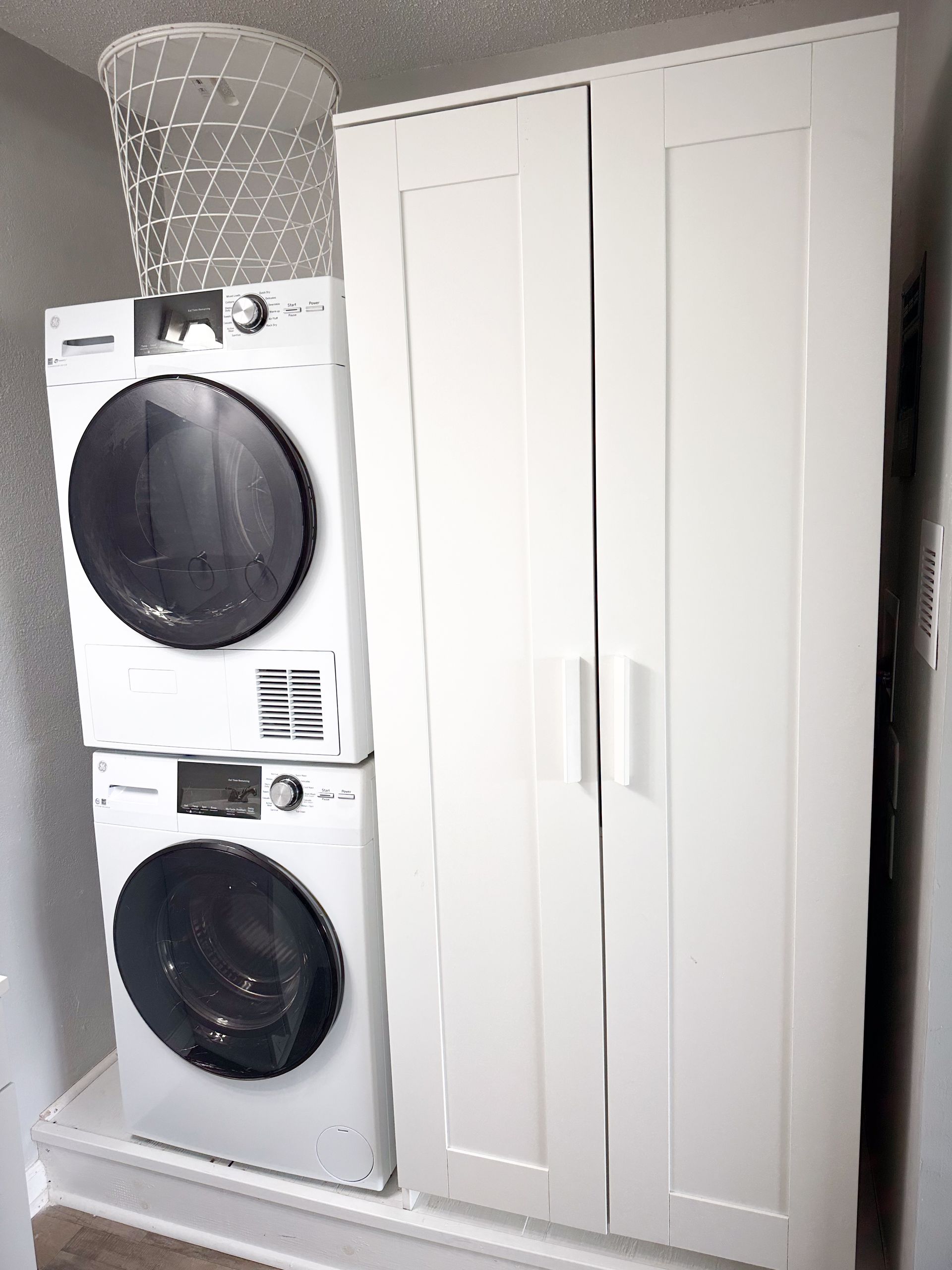 A washer and dryer are stacked on top of each other in a laundry room.