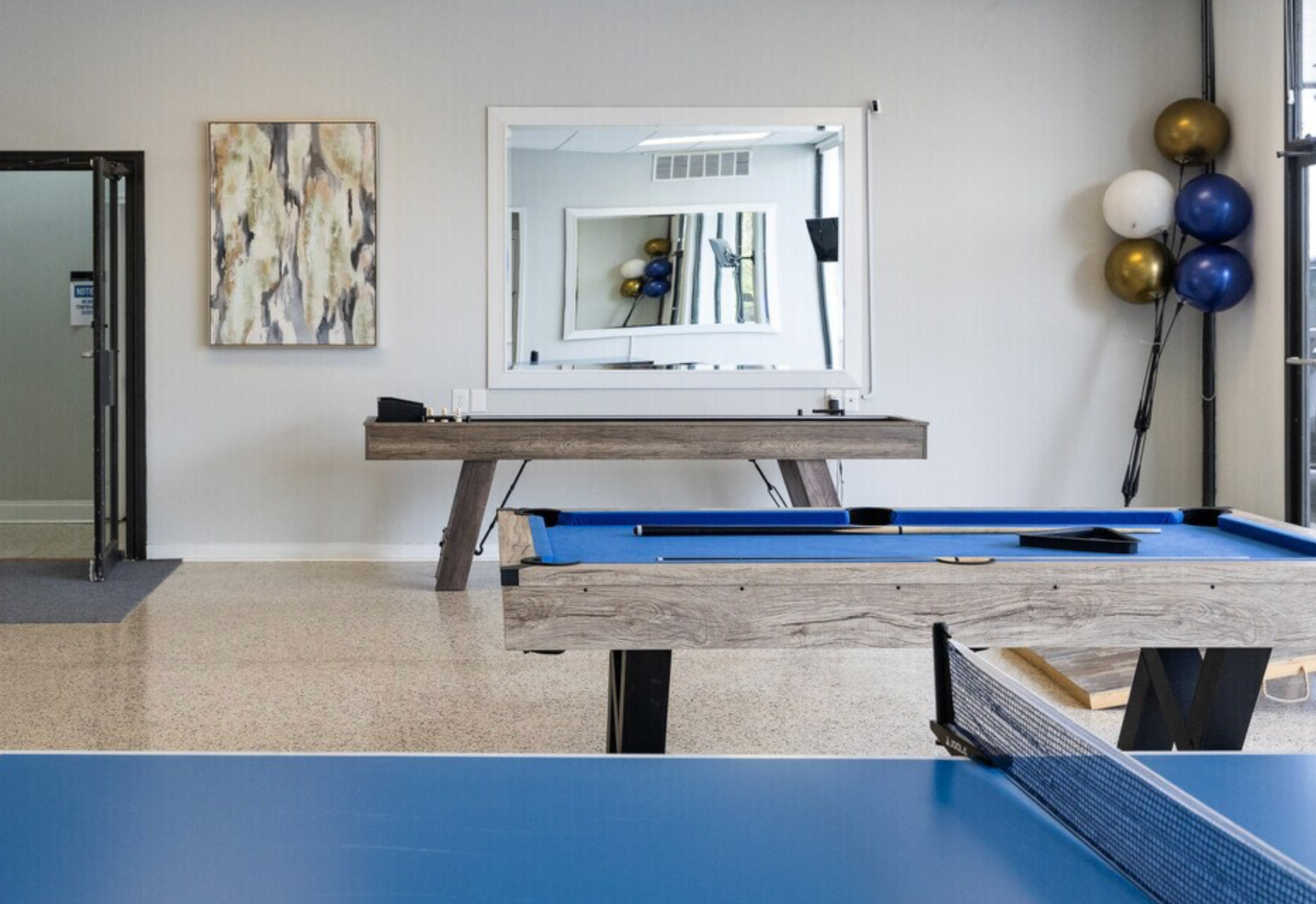 A pool table and ping pong table in a room