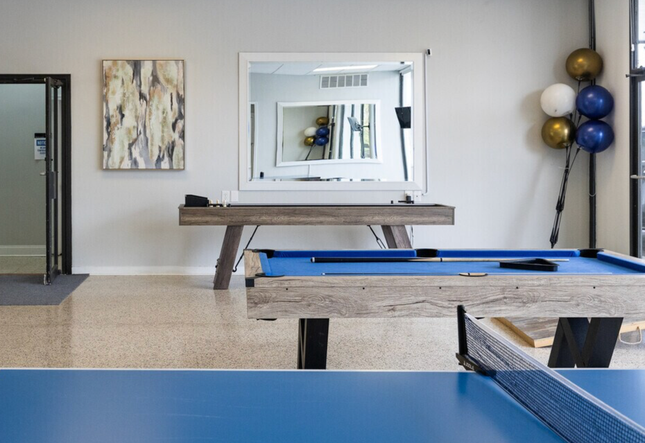 A pool table and ping pong table in a room