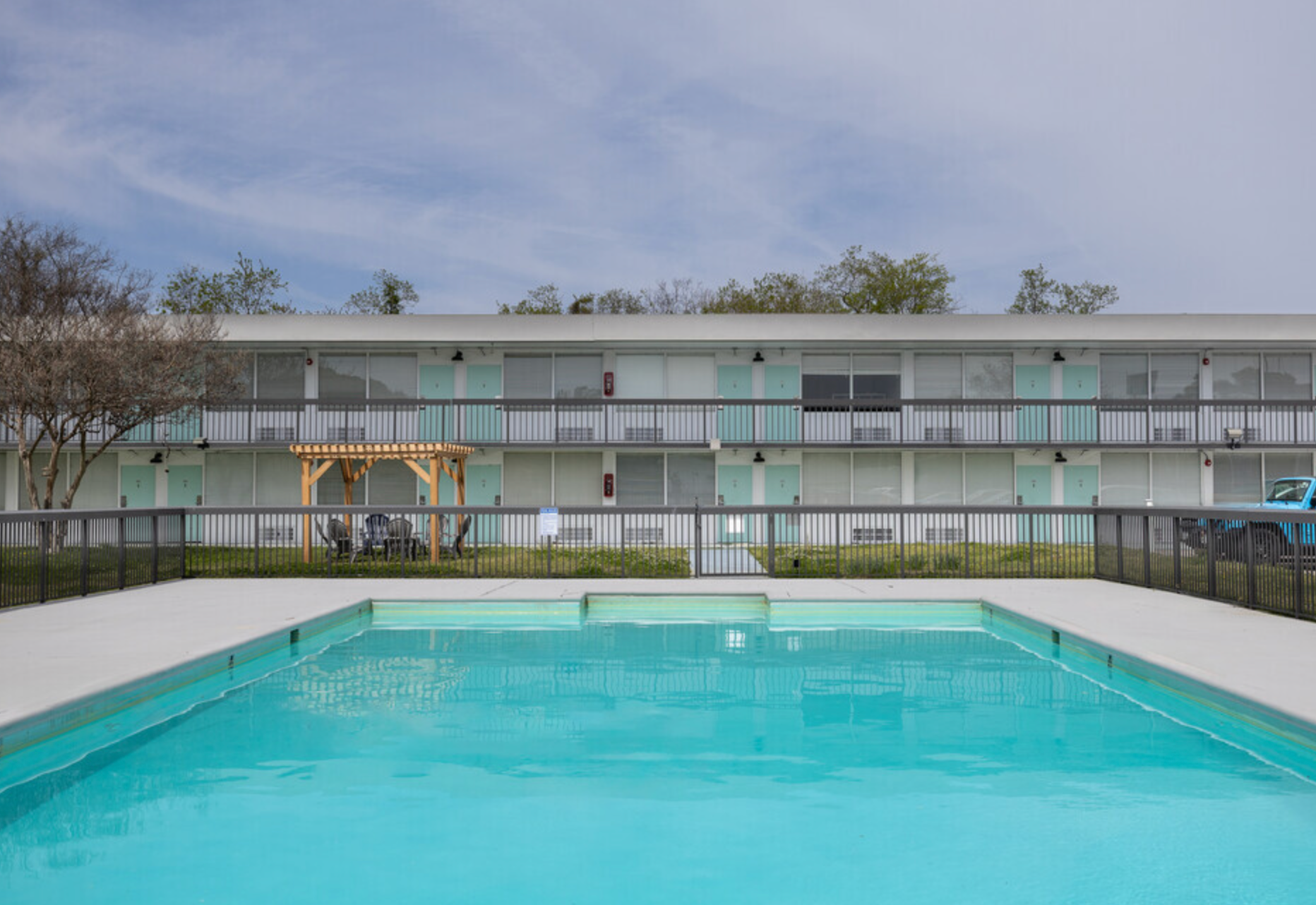 A large swimming pool in front of a large building.