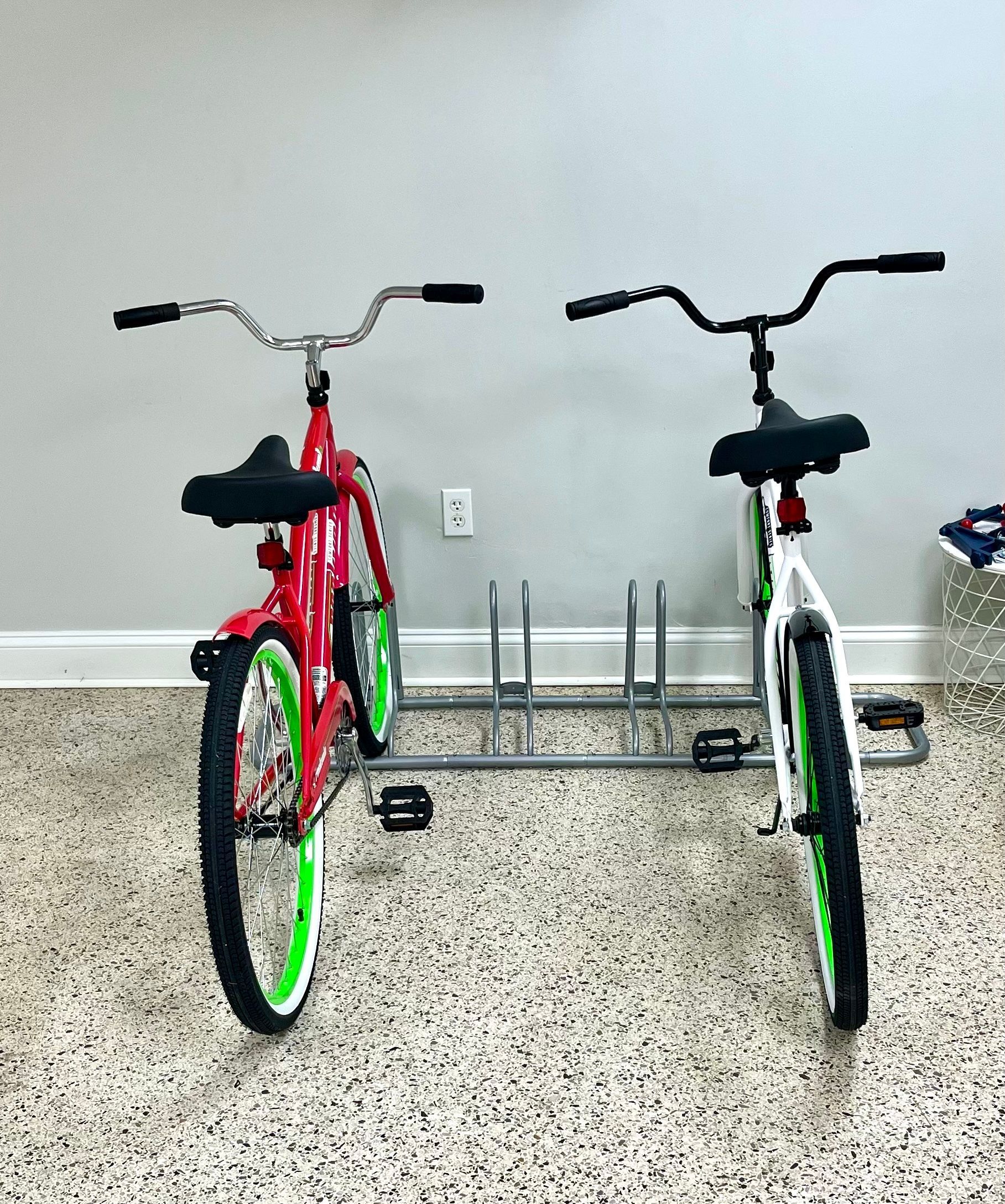 Two bicycles are parked on a rack in a garage.