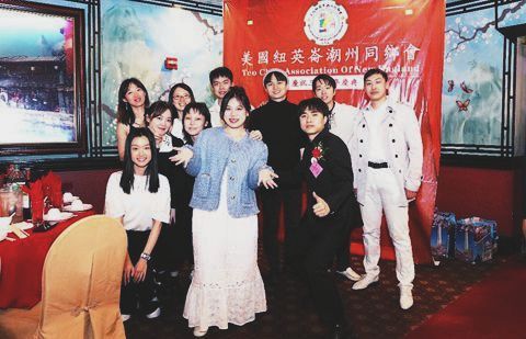 A group of people are posing for a picture in front of a red banner.