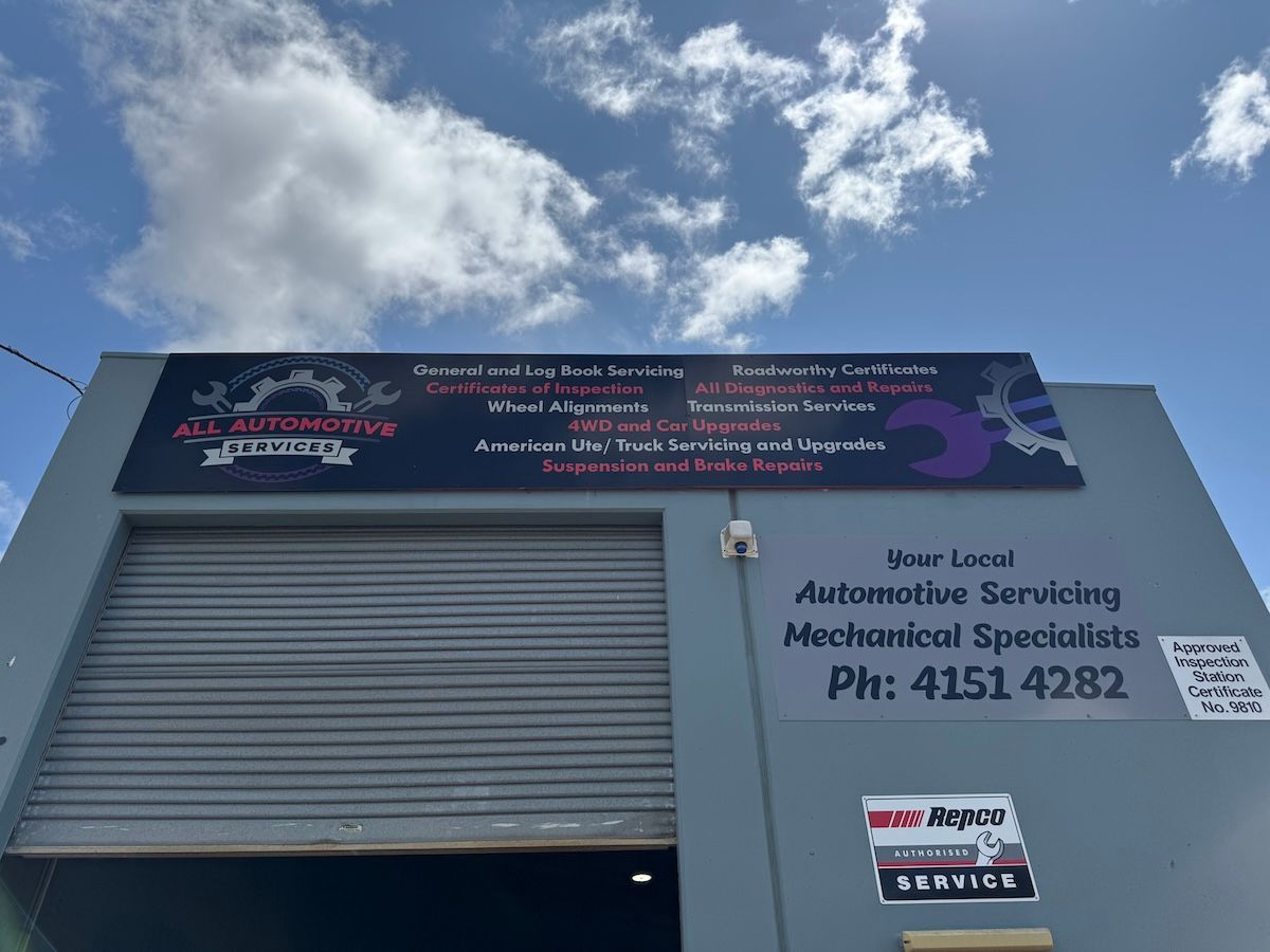 A Car Is Sitting On A Lift In A Garage — All Automotive Services In Bundaberg East, QLD